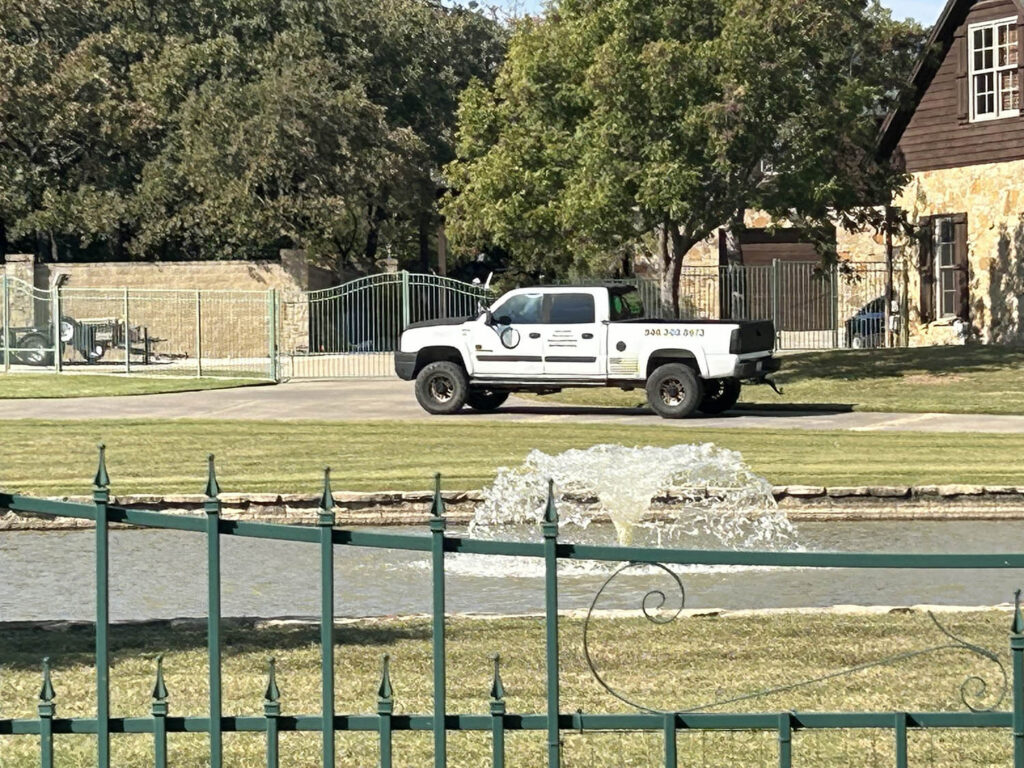 Open Hands Cleaning Services truck parked at a DFW estate driveway with fountain