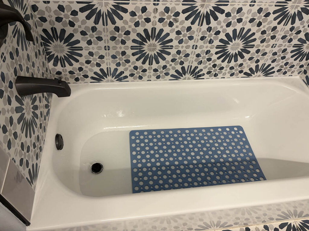White bathtub with patterned tile surround after a deep clean