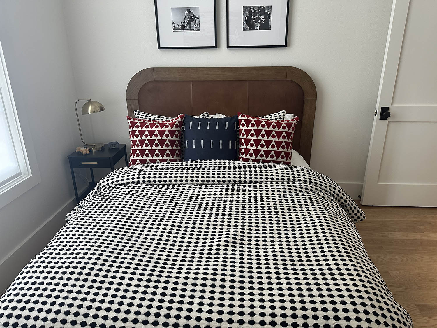Made bed with a geometric duvet in a clean bedroom after a recurring house cleaning
