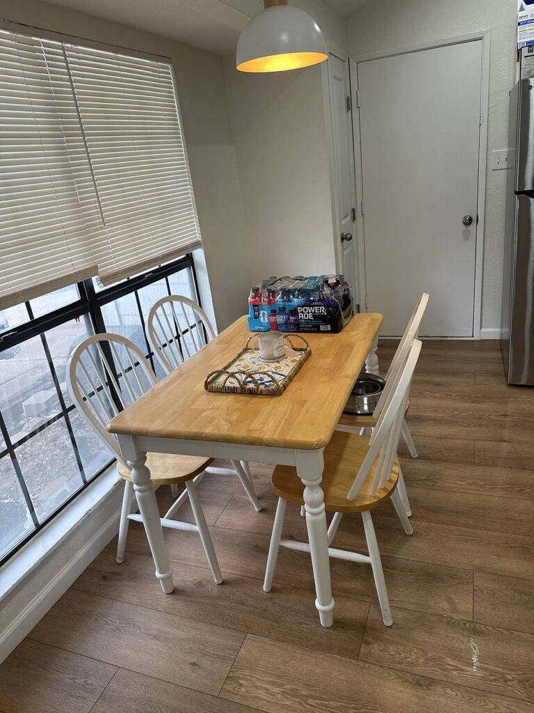 Breakfast nook with a wood table and white chairs after a house cleaning