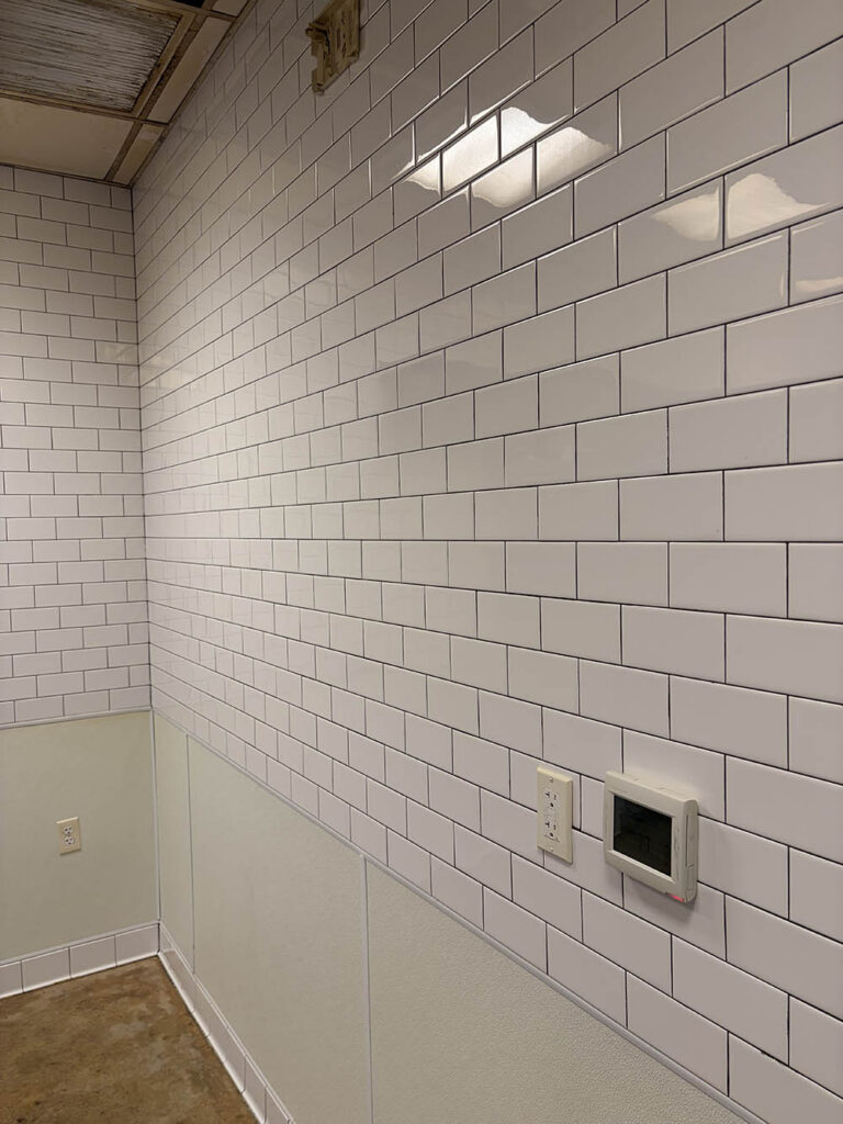 Empty commercial kitchen with subway tile walls after cleaning