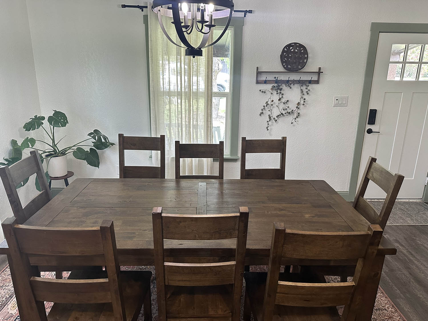 Dining room with a farmhouse table set for guests after a party cleaning