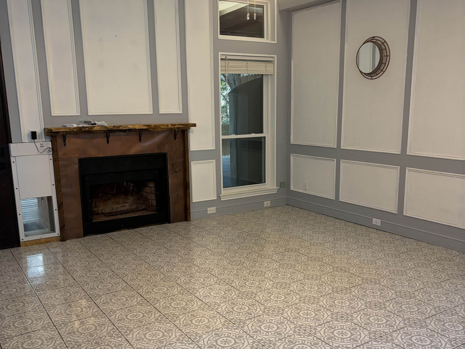 Empty living room with fireplace and patterned tile floor after a move-out clean