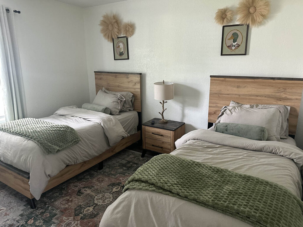 Guest bedroom with two made twin beds after a recurring house cleaning