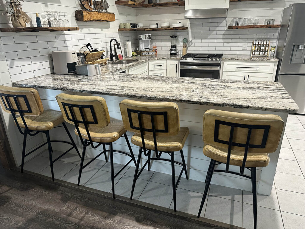 Kitchen with a granite island and bar stools after an Open Hands deep clean