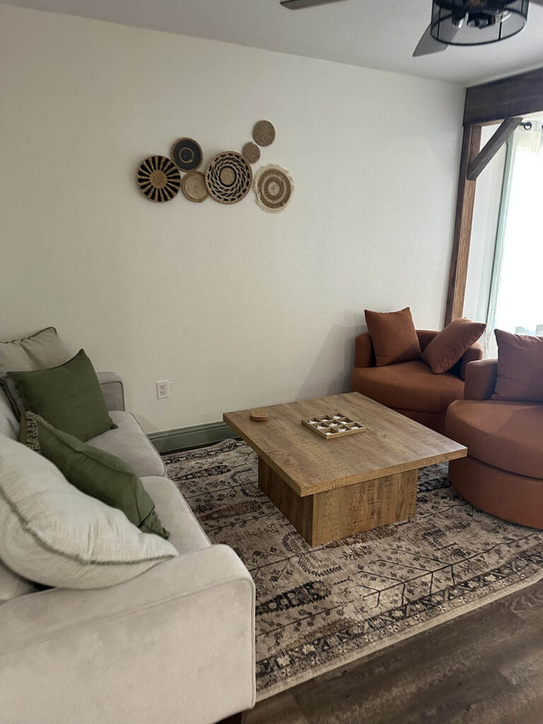 Living room with a sofa, area rug, and wood coffee table after a house cleaning
