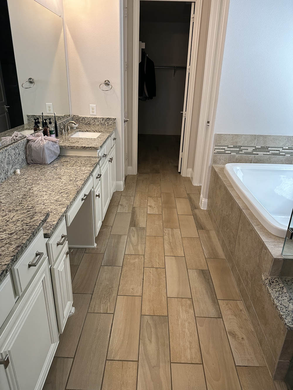 Master bathroom with granite vanity and garden tub after a deep clean
