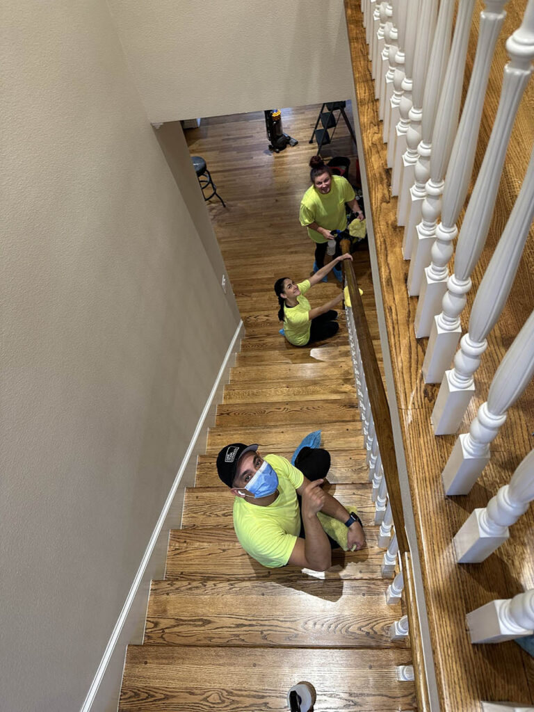 open-hands-crew-cleaning-staircase-spindles-yellow-uniform-legacy