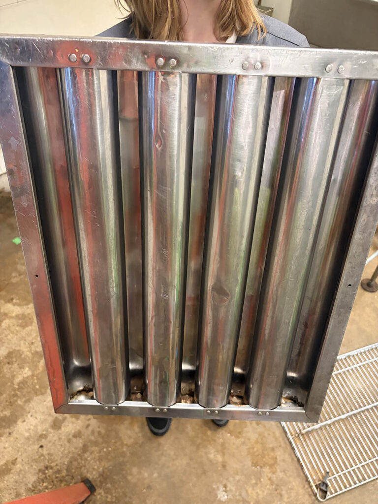 Kitchen hood filter held up during a commercial kitchen degreasing