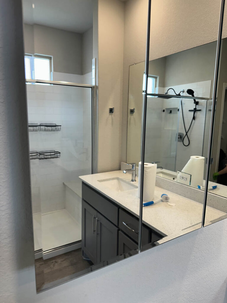 New-construction bathroom vanity and glass shower during final cleaning