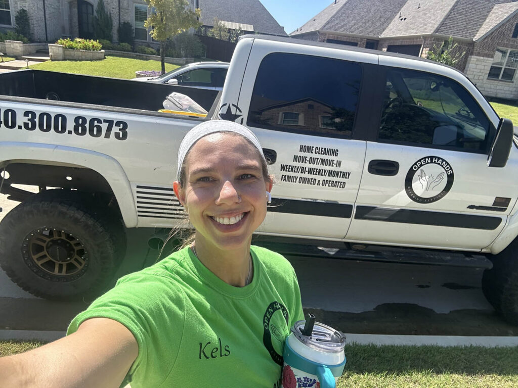 open-hands-owner-selfie-branded-truck-driveway-green-uniform-legacy