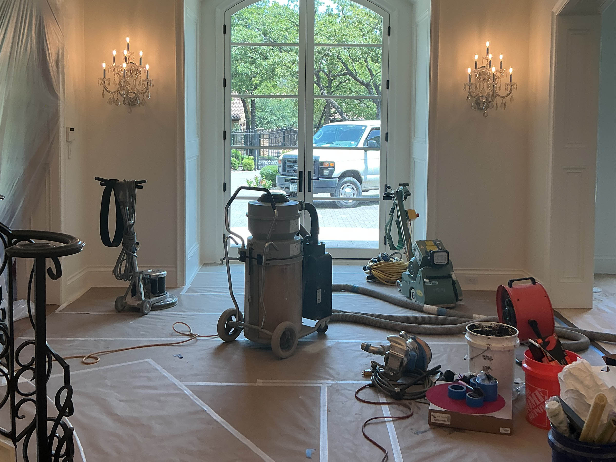 Entry with arched French doors and floor equipment during post-construction cleanup